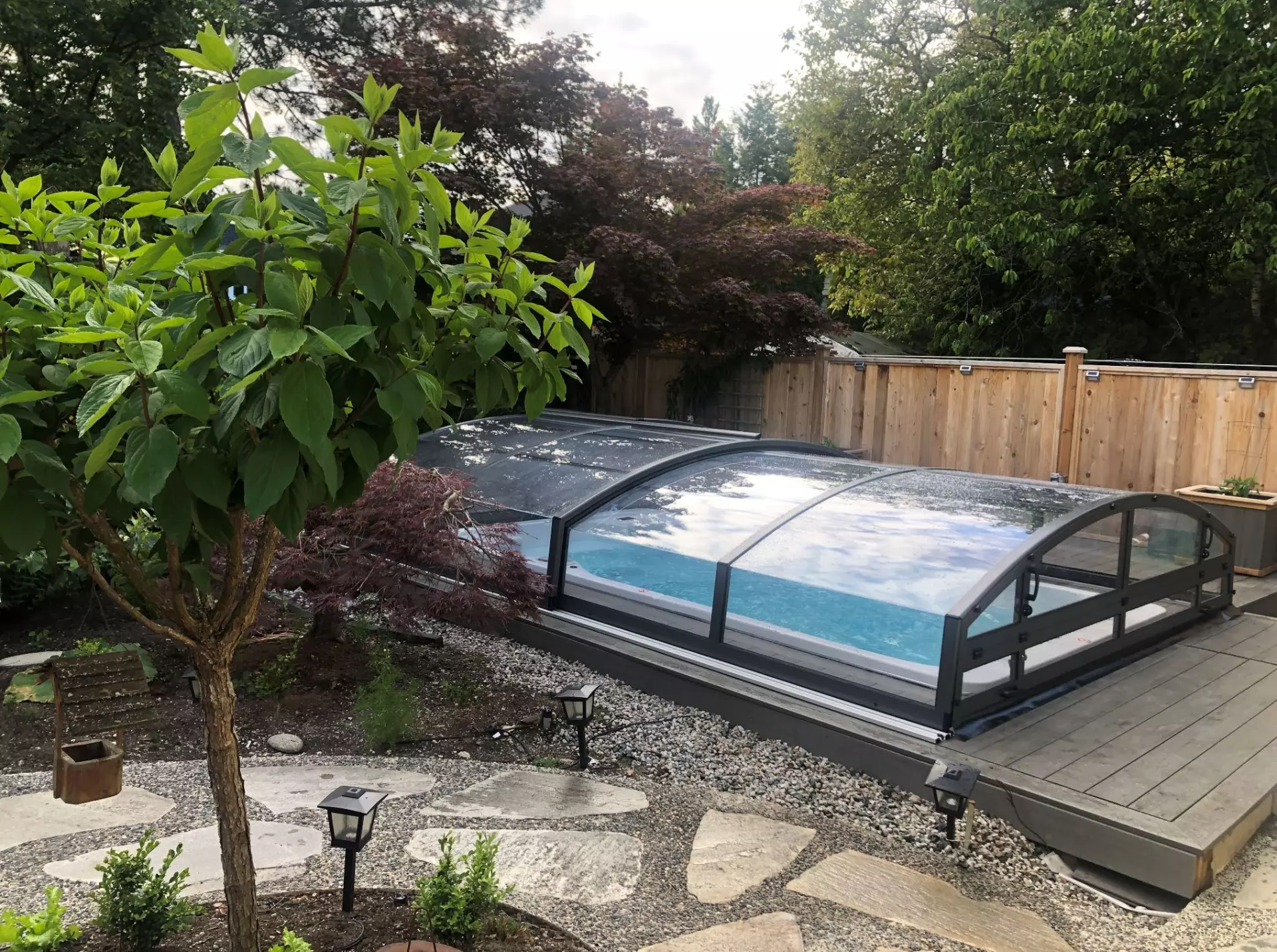 Retractable pool cover protecting outdoor pool from leaves and debris