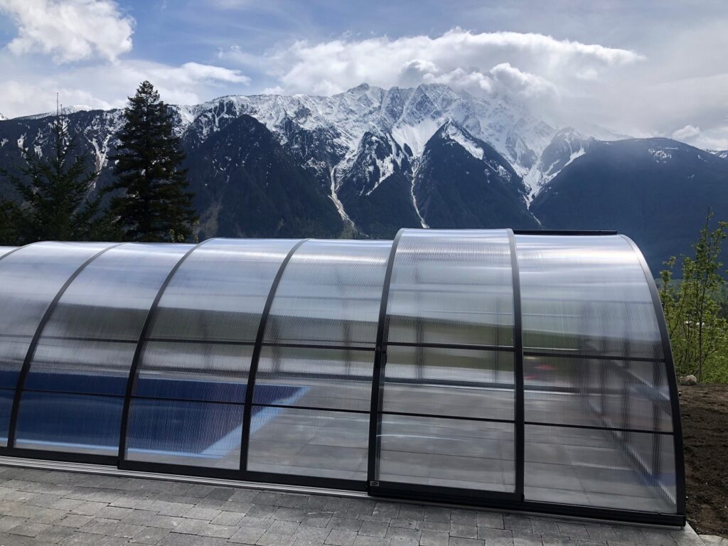 High retractable pool enclosure over outdoor pool with mountains in the background